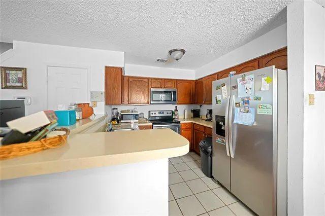 a kitchen with stainless steel appliances granite countertop a refrigerator a stove top oven a sink and dishwasher