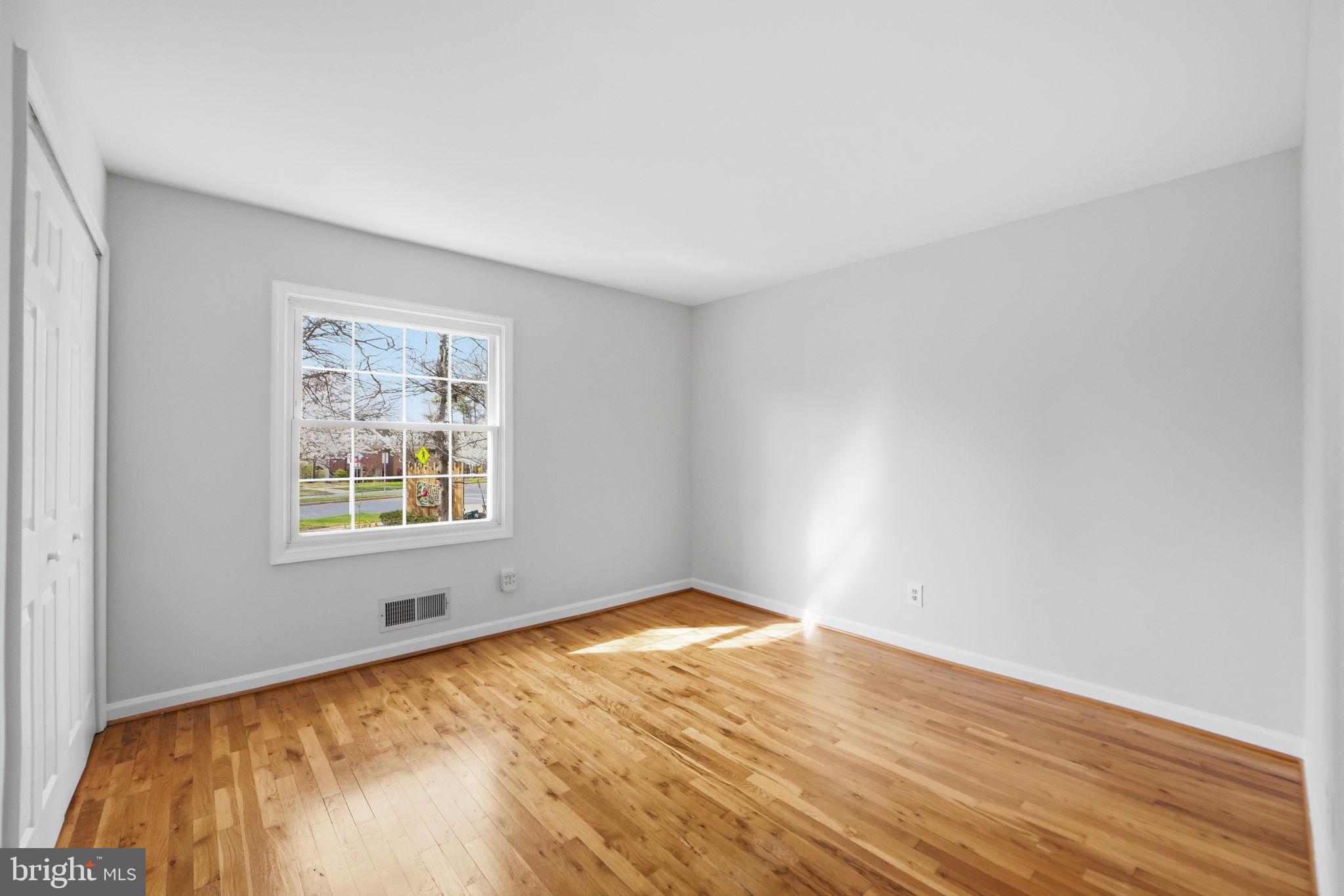 8230 Carrleigh Parkway, Unit 84 Springfield, VA 22152 - Photo 20 of 28 an empty room with wooden floor and windows
