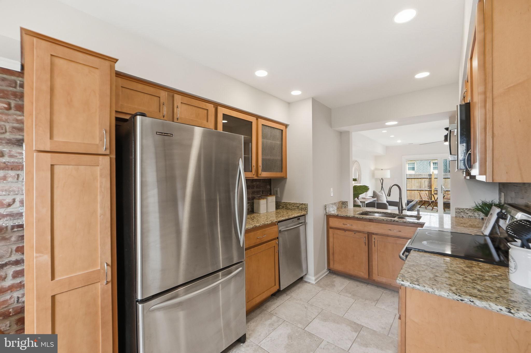 8230 Carrleigh Parkway, Unit 84 Springfield, VA 22152 - Photo 9 of 28 a kitchen with stainless steel appliances granite countertop a refrigerator stove and sink