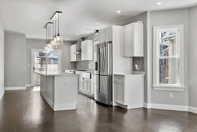 a kitchen with stainless steel appliances a refrigerator and wooden floor