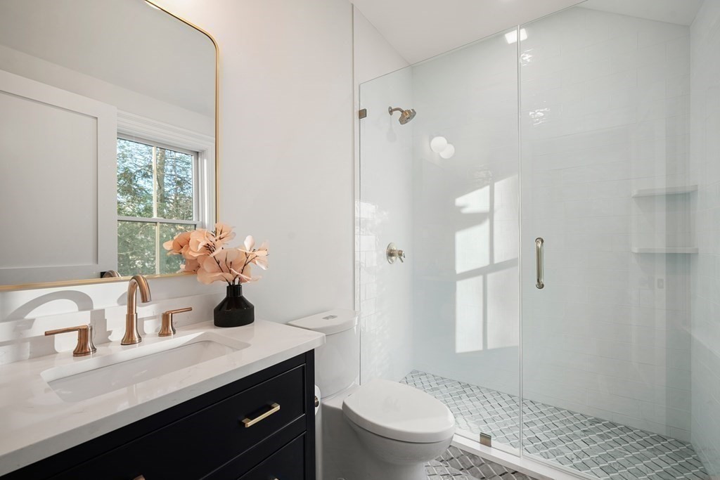 6 Juniper Place Lexington, MA 02420 - Photo 20 of 32 a bathroom with a granite countertop sink a toilet and shower