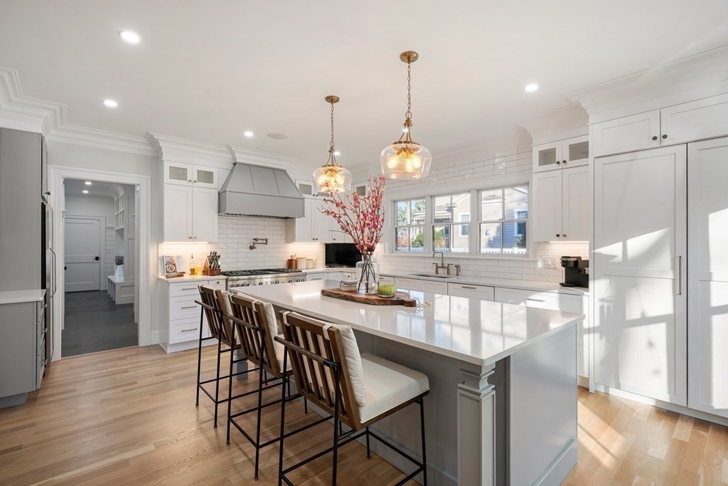 6 Juniper Place Lexington, MA 02420 - Photo 9 of 32 a kitchen with stainless steel appliances kitchen island granite countertop a table chairs and a refrigerator