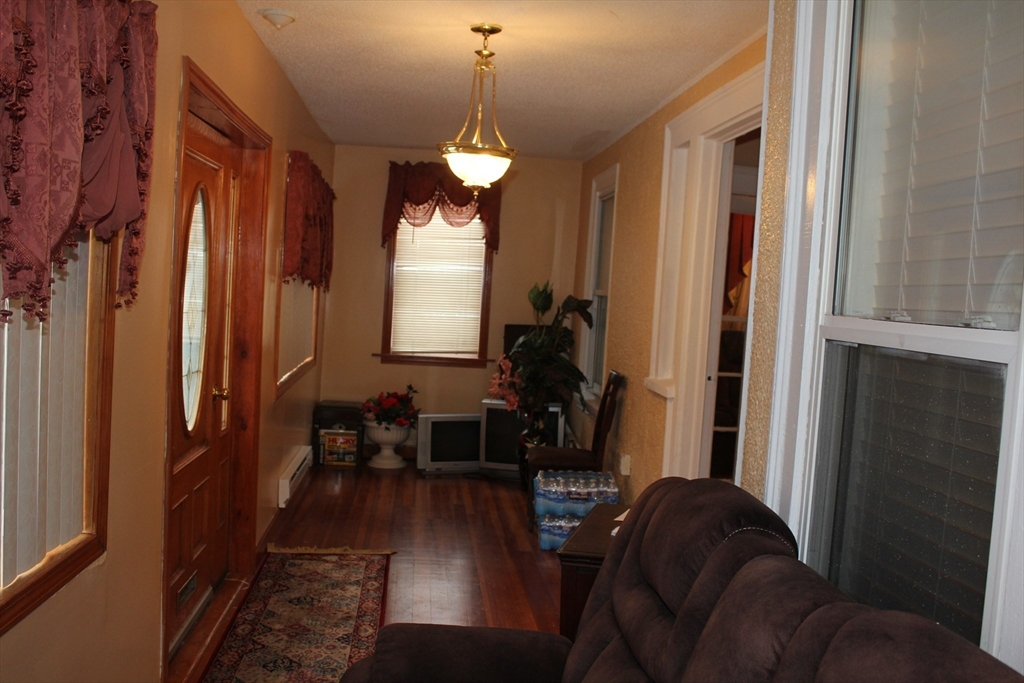 618 Harvard Street Boston, MA 02126 - Photo 11 of 42 a living room with furniture chandelier and a window