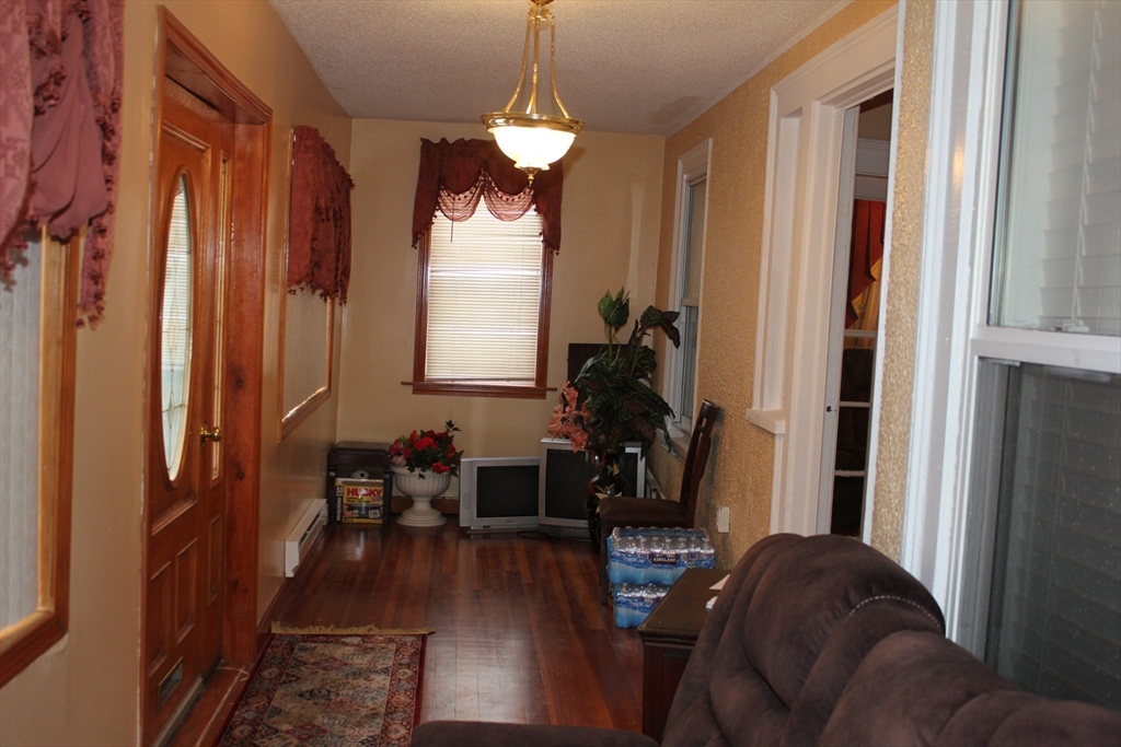 618 Harvard Street Boston, MA 02126 - Photo 12 of 42 a living room with furniture and a chandelier