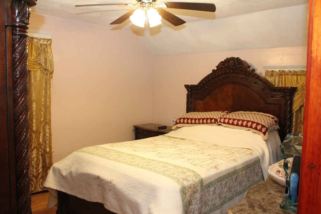 618 Harvard Street Boston, MA 02126 - Photo 30 of 42 a bedroom with a bed and a chandelier