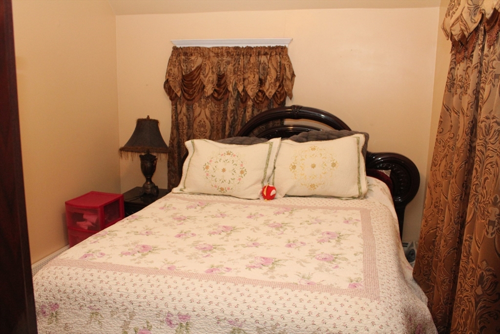 618 Harvard Street Boston, MA 02126 - Photo 33 of 42 a bedroom with a bed and wooden floor