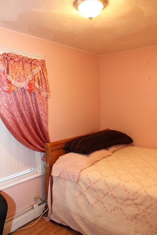 618 Harvard Street Boston, MA 02126 - Photo 36 of 42 a bedroom with a bed and a view of cupboard