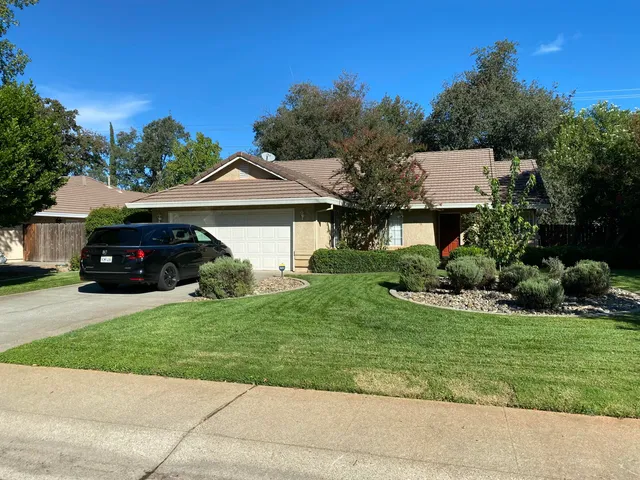a front view of a house with a garden