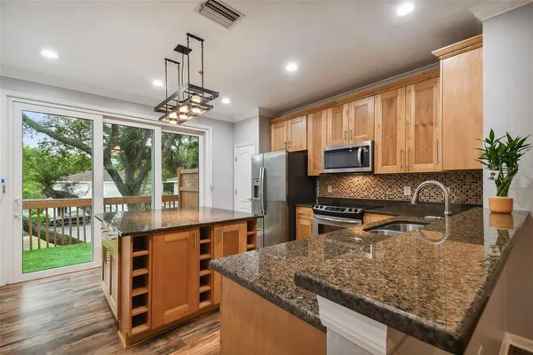 a kitchen with stainless steel appliances granite countertop a stove top oven a sink with granite countertops and cabinets