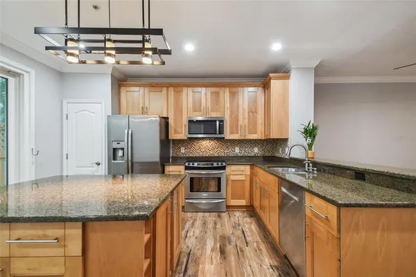 a kitchen with stainless steel appliances granite countertop a sink stove and refrigerator