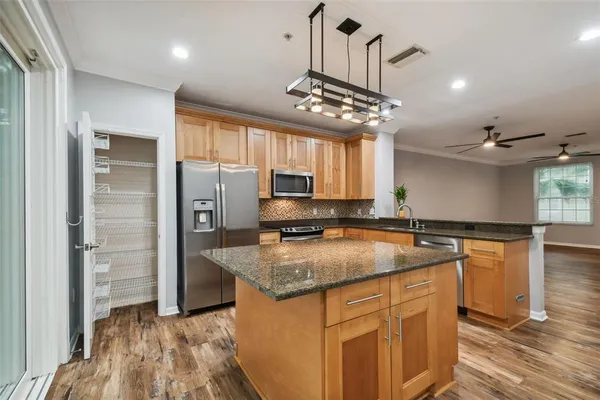 a kitchen with stainless steel appliances granite countertop a sink stove and refrigerator