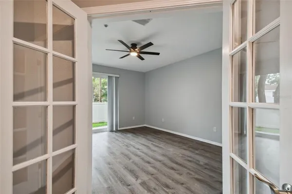 a view of room with a ceiling fan and wooden floor