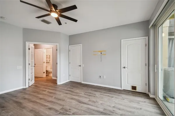 an empty room with closet and a ceiling fan