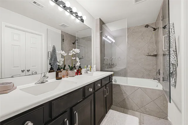 a bathroom with a double vanity sink mirror and shower