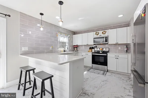 a kitchen with kitchen island a sink counter top space appliances and cabinets