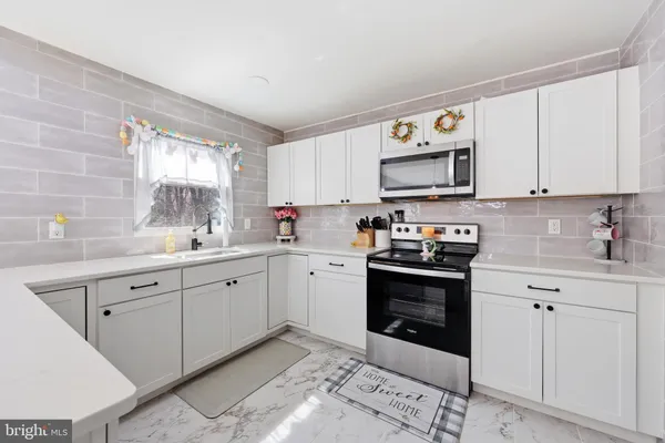 a kitchen with cabinets stainless steel appliances and a window