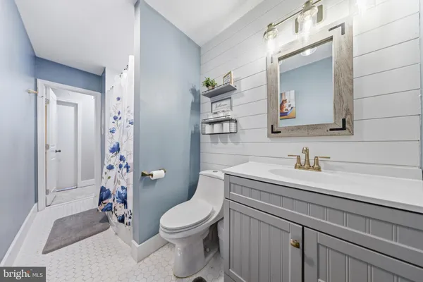 a bathroom with a granite countertop toilet sink and mirror