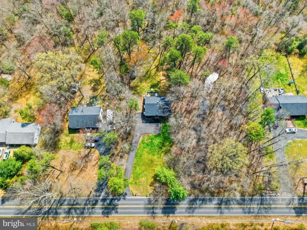 a aerial view of a house with a yard and large trees