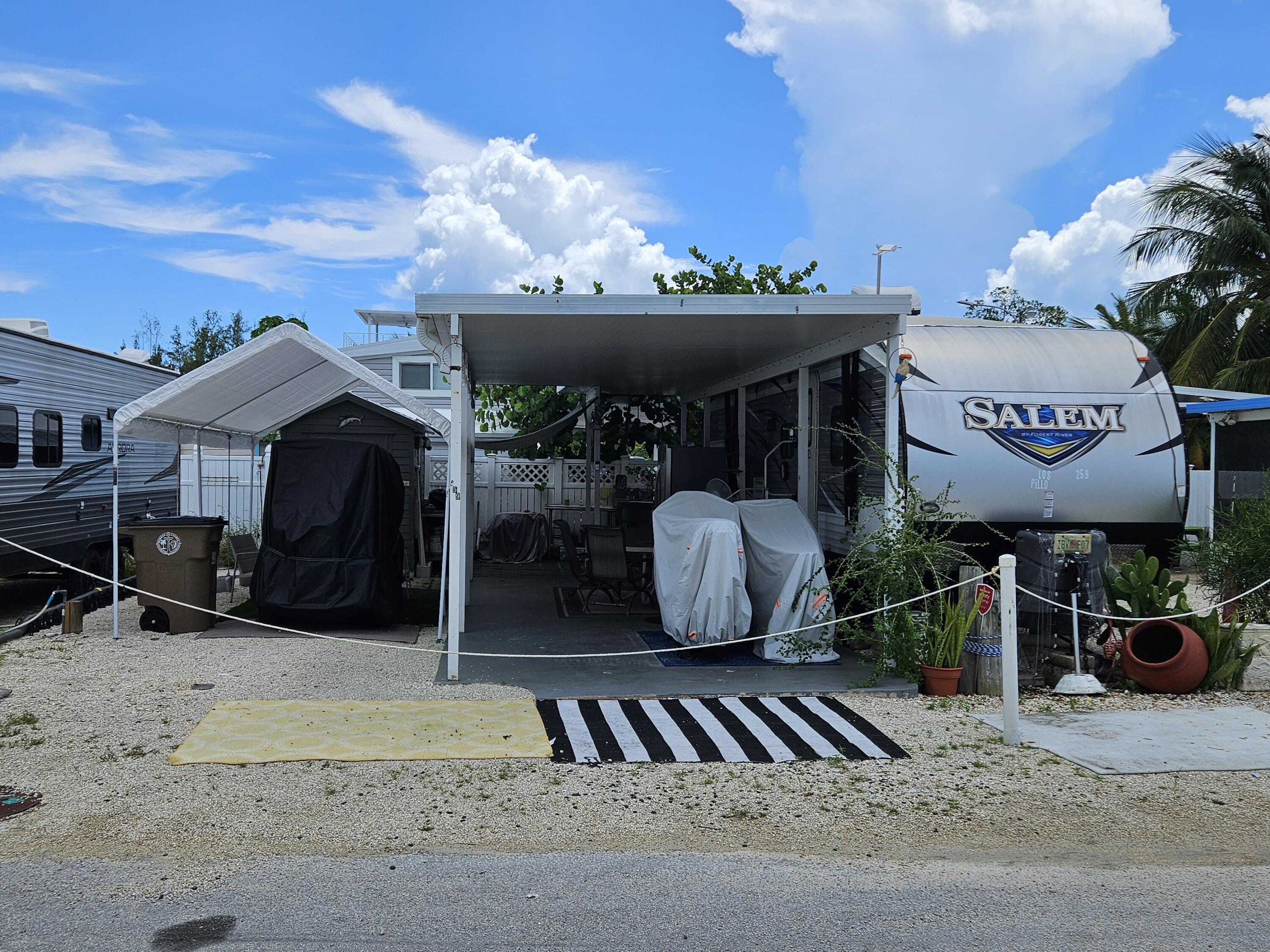 325 Calusa Street, Unit 259 Key Largo, FL 33037 - Photo 1 of 12 a view of a chairs and table in backyard