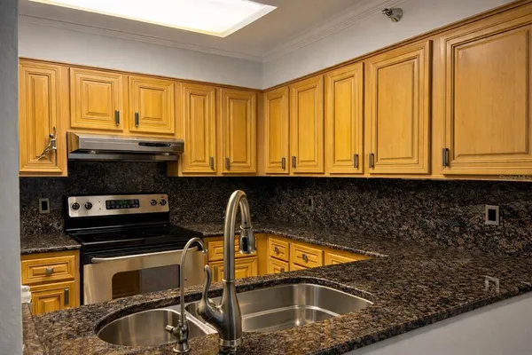 a kitchen with stainless steel appliances granite countertop a refrigerator sink and cabinets
