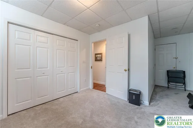 a living room with furniture a bookshelf and a window