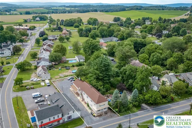 an aerial view of residential houses with outdoor space and trees