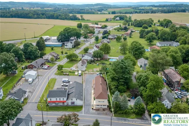 an aerial view of a house with a garden and lake view