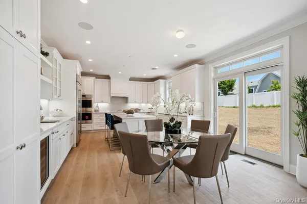 a kitchen with stainless steel appliances granite countertop a stove a sink a dining table and chairs