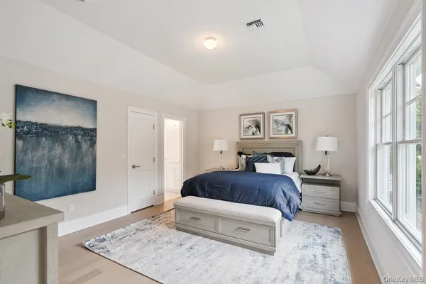 a bedroom with a bed and dresser with mirror