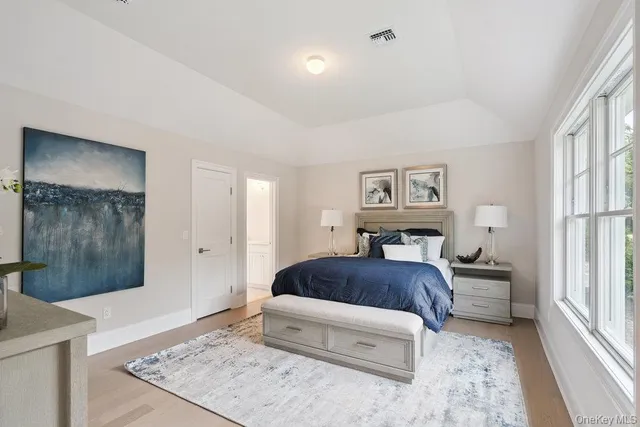 a bedroom with a bed and dresser with mirror