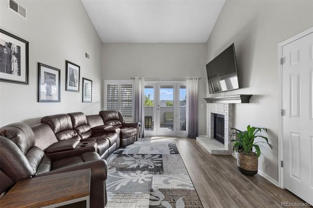 a living room with furniture a fireplace and a potted plant