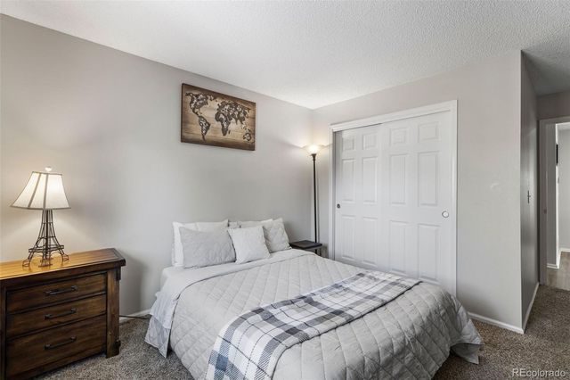 a bedroom with a bed and a lamp on the dresser