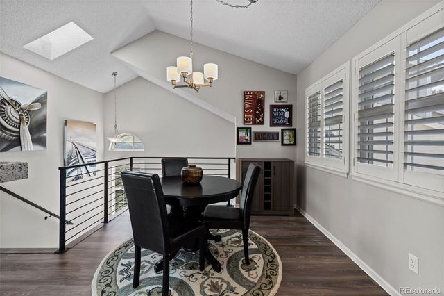a view of a dining room with furniture wooden floor and chandelier