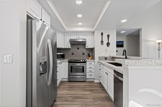 a kitchen with stainless steel appliances a refrigerator sink and stove