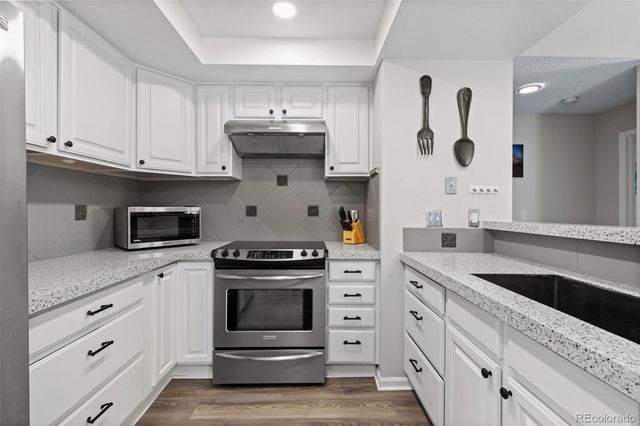 a kitchen with white cabinets and appliances