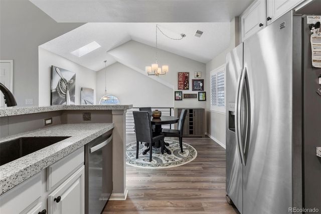 a kitchen with stainless steel appliances granite countertop a refrigerator and a sink
