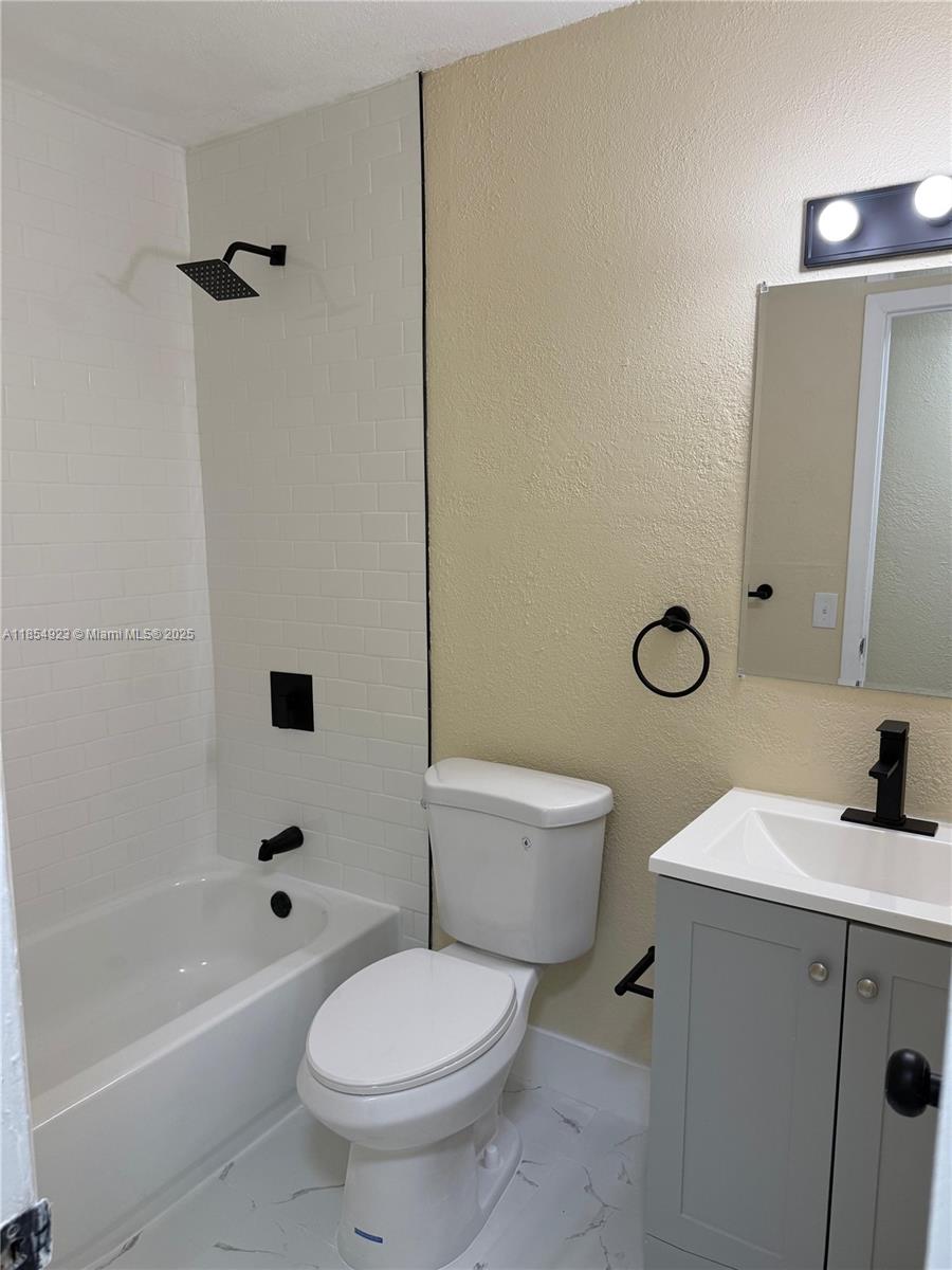 2310 West 60th Street, Unit 9G Hialeah, FL 33016 - Photo 11 of 15 a white toilet sitting next to a bath tub