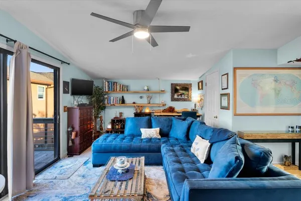 a living room with furniture and a view of kitchen