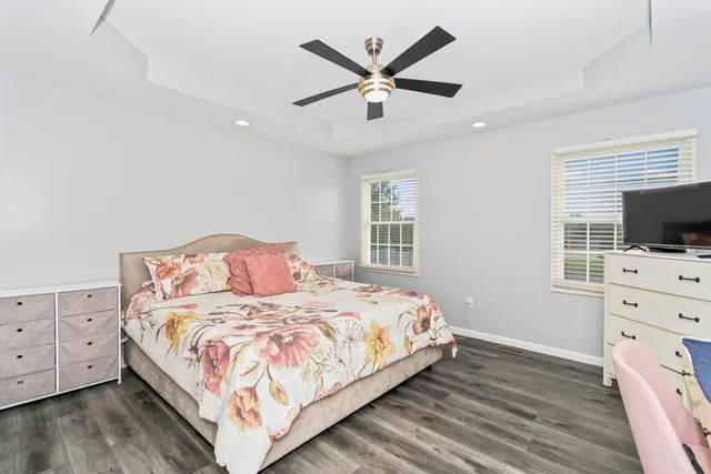 a bedroom with a large bed and a flat tv screen on dresser