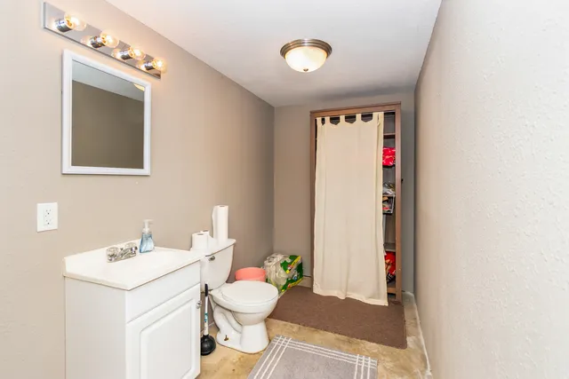 a bathroom with a toilet sink and mirror