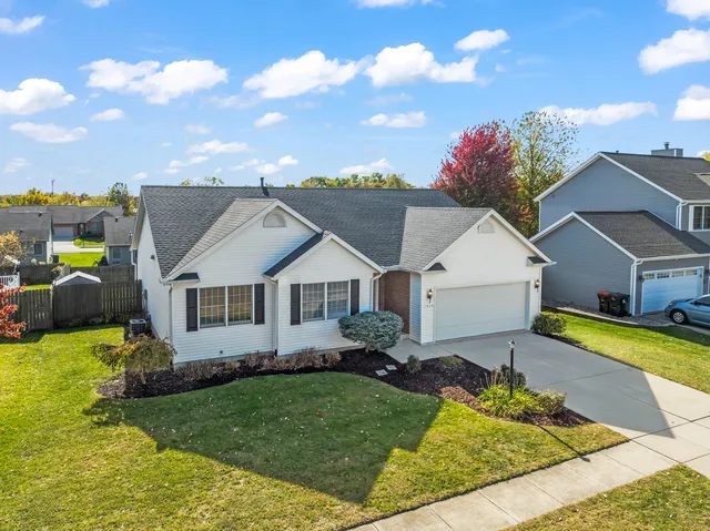 a view of a house with a big yard potted plants and large tree
