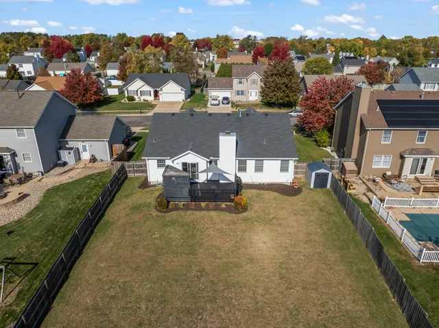 an aerial view of a house with a garden and lake view