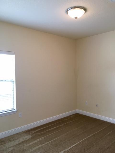 624 Red Fern Road Crestview, FL 32536 - Photo 20 of 26 an empty room with wooden floor and windows