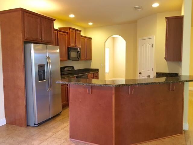 624 Red Fern Road Crestview, FL 32536 - Photo 7 of 26 a kitchen with stainless steel appliances granite countertop a refrigerator a stove and a sink with wooden cabinets