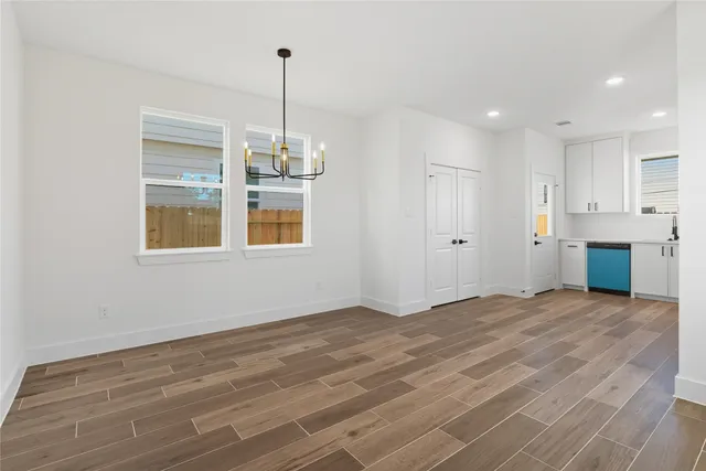 a view of an empty room with window and cabinet