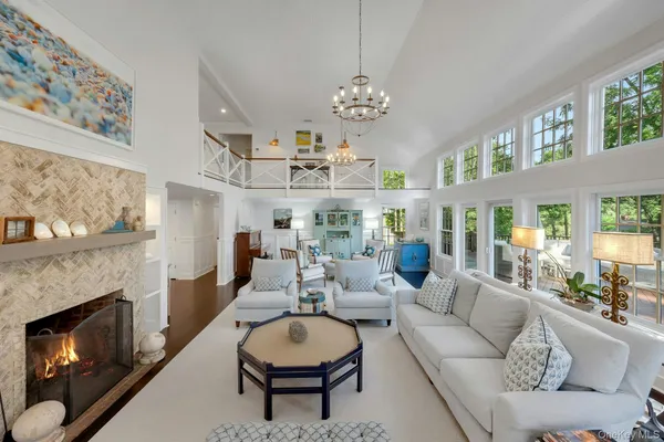 a living room with furniture a fireplace and a large mirror