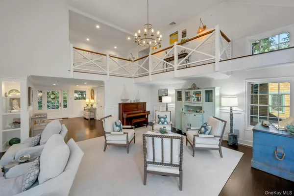 a living room with furniture a fireplace and a chandelier