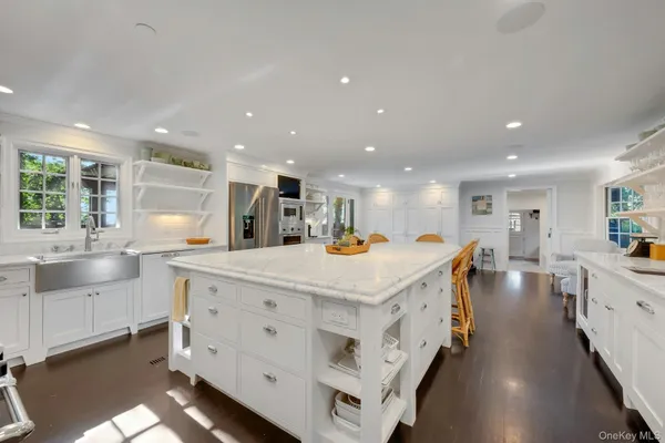 a large kitchen with kitchen island lots of counter space a sink a window and stainless steel appliances