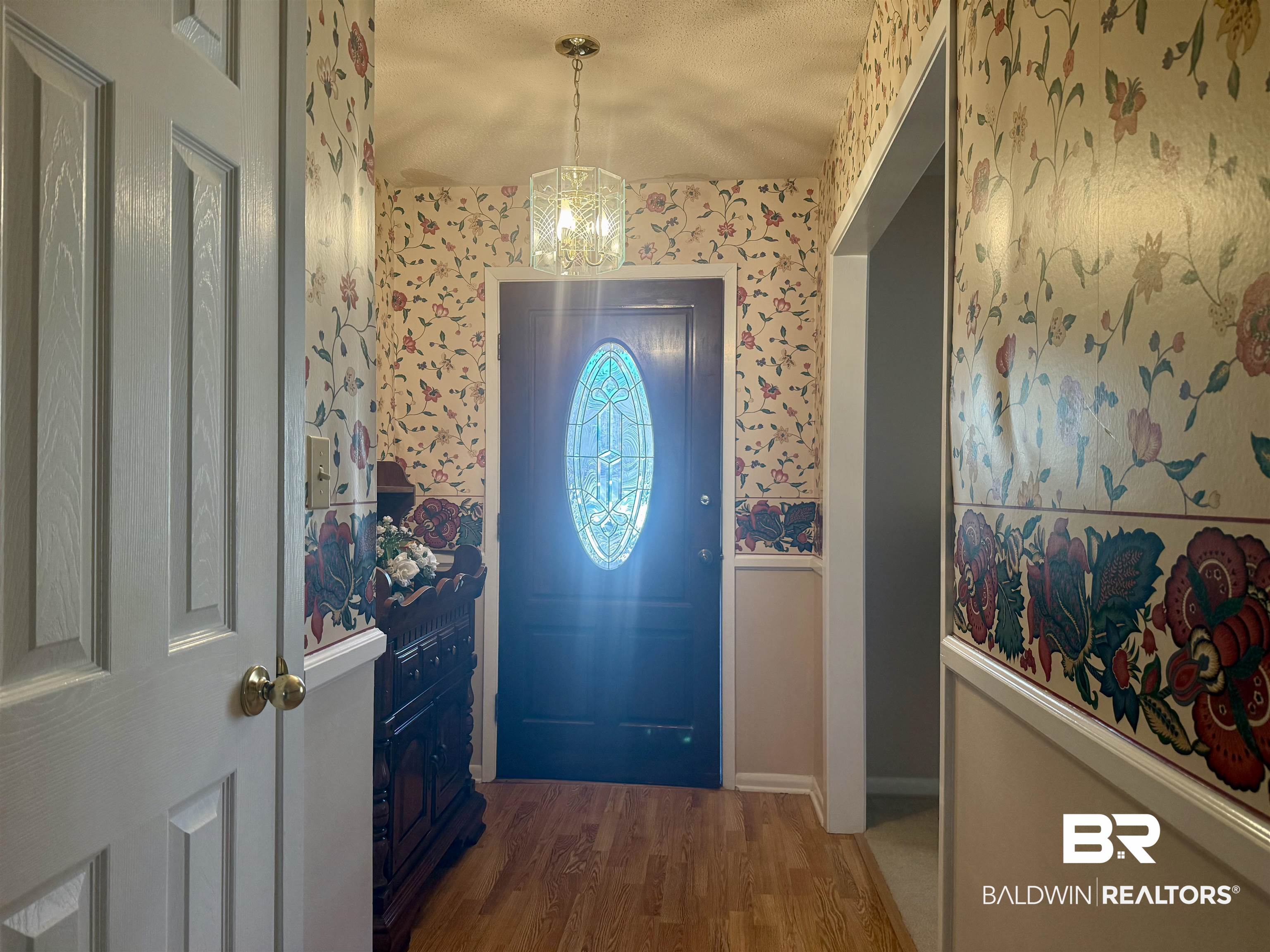 215 Young Street Brewton, AL 36426 - Photo 8 of 25 Foyer entrance with wood finished floors and wallpapered walls