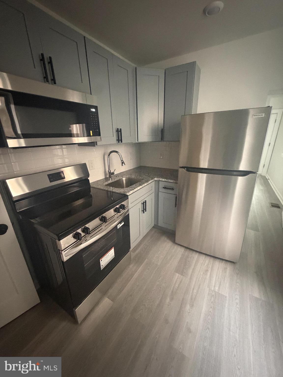 112 East Huntingdon Street, Unit 1 Philadelphia, PA 19125 - Photo 1 of 10 a kitchen with wooden cabinets and stainless steel appliances